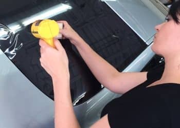 Car window tinting film being installed